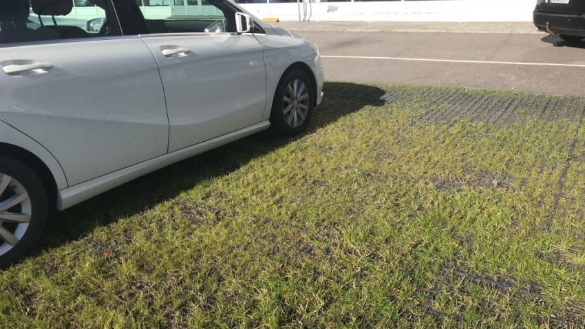 Ecoraster maakennot asennettuna nurmitäytöllä autoliikkeen paikoitusalueelle..