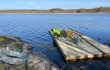 Lintusaareen, joka on puusta valmistettu lautta, asennetaan reunalistoja Lepinjärvellä Karjaalla. Asentaja Eg-Trading Oy.
